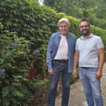 Alfred und Cengiz Ketecioglu vor einer Steinfigur im Fengshui-Garten auf dem Campus Erlangen
